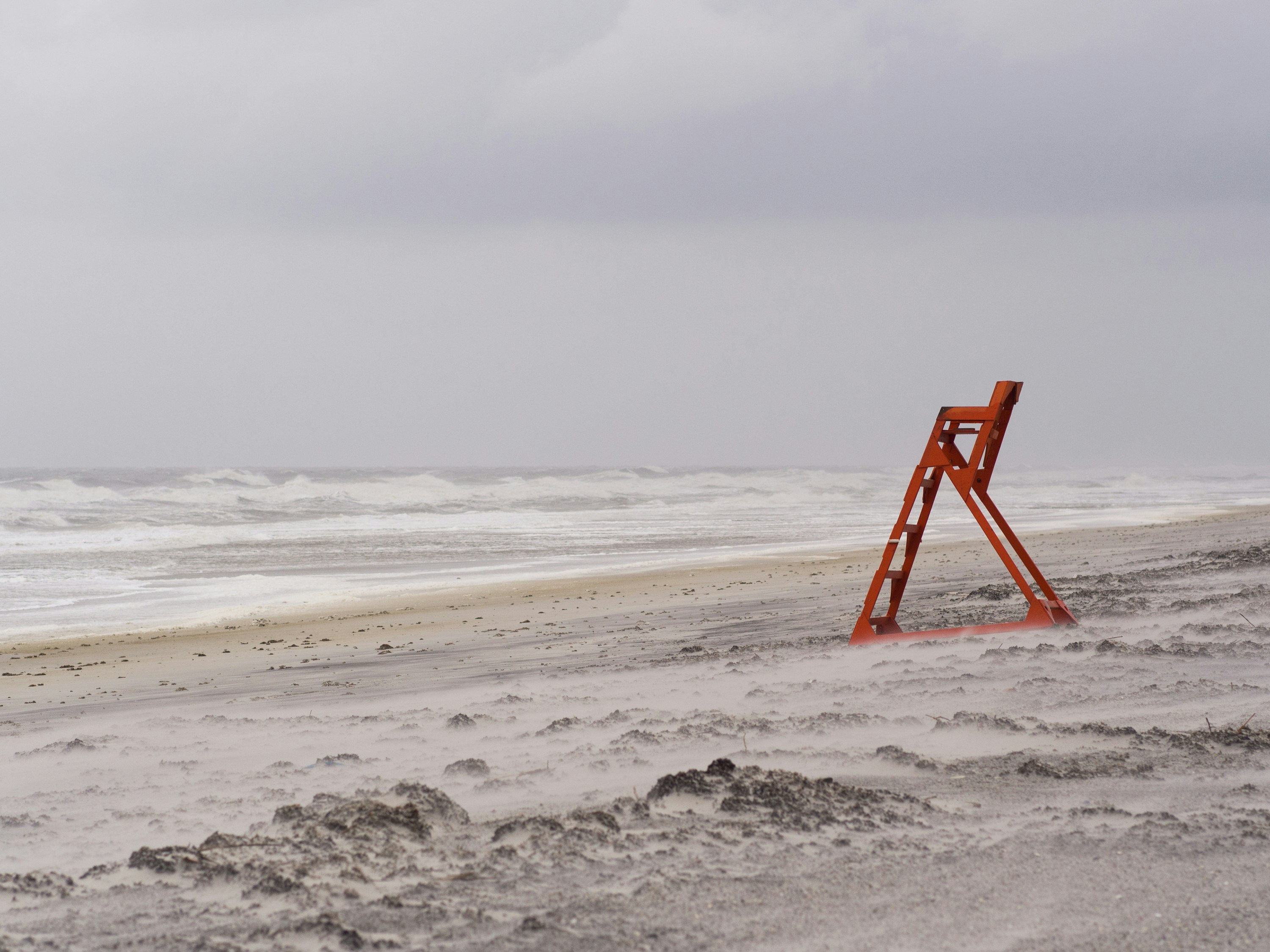 red metal ladder stand near seashore during daytime